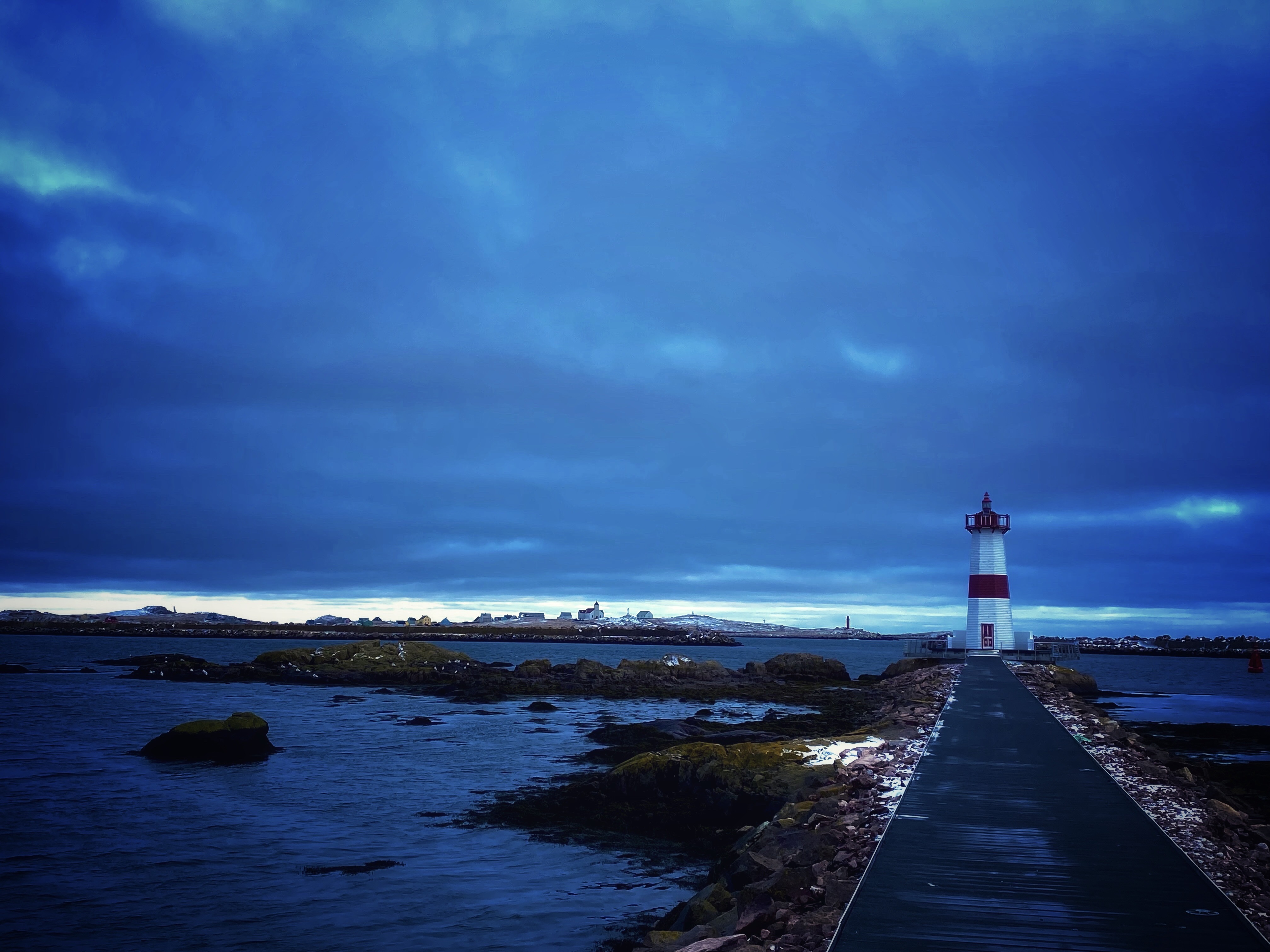 Phare de la pointe aux canons derrière lesquel s'esquisse l'île aux marins. © Jean-Christophe Mojard, 2023