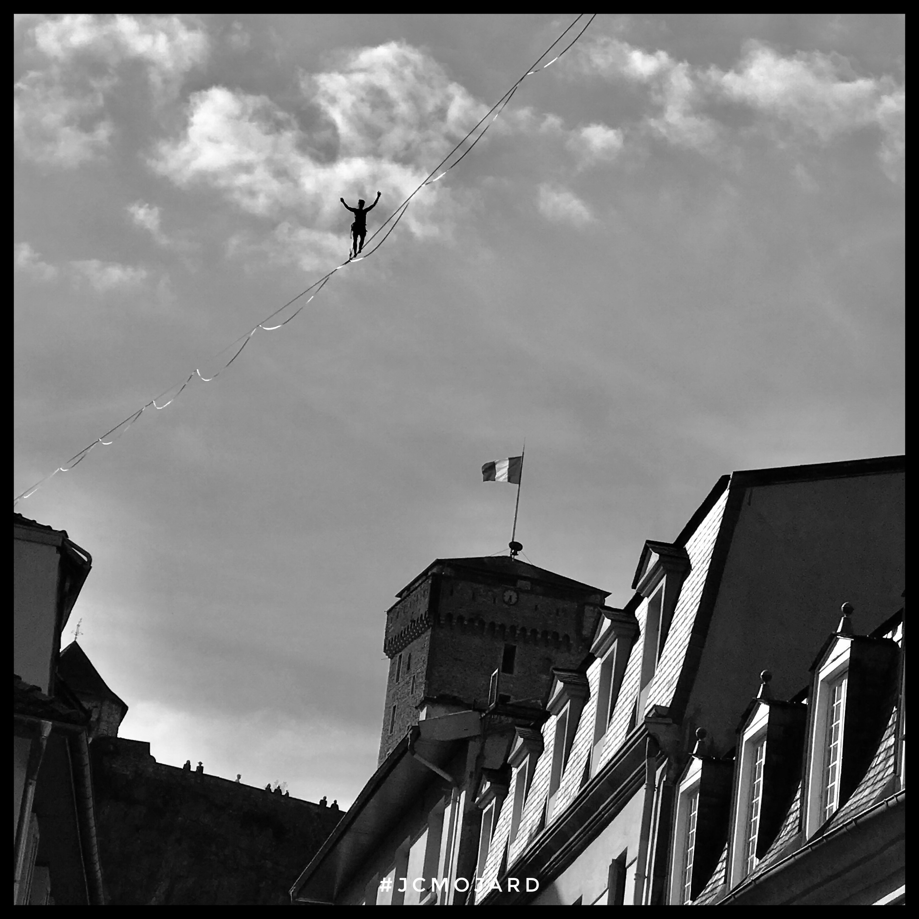 Funambule sur son cable d'acier tendu au-dessus de la ville de Lourdes, au départ du château.